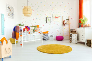 babykamer decoratie idee met kleedje en pastelkleuren